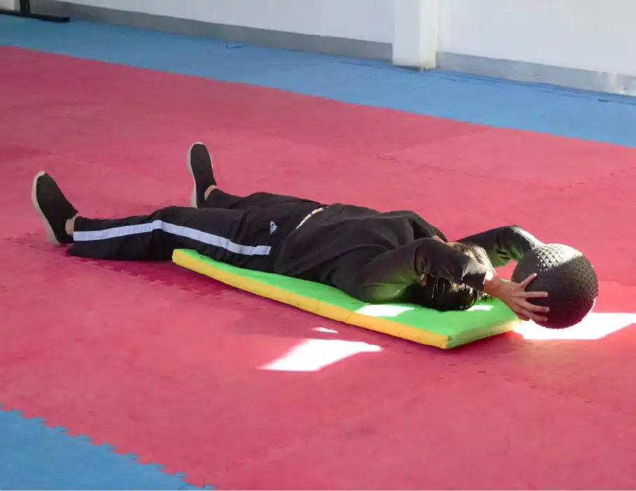 Adulto realizando ejercicio de abdomen con balón medicinal en clases de acondicionamiento físico en Lobos TKD Pachuca