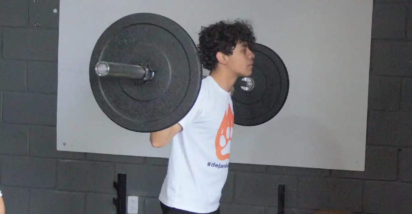 Adulto realizando sentadilla con barra olímpica durante clases de acondicionamiento físico en Lobos TKD Pachuca