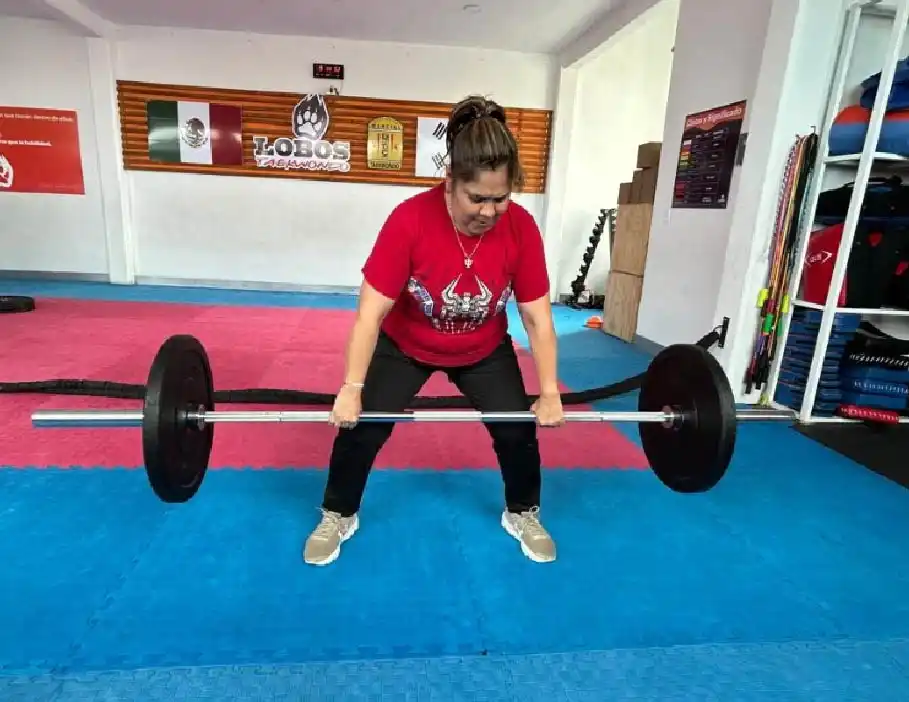 Mujer adulta entrenando levantamiento con barra olímpica en clases de acondicionamiento físico en Lobos TKD Pachuca