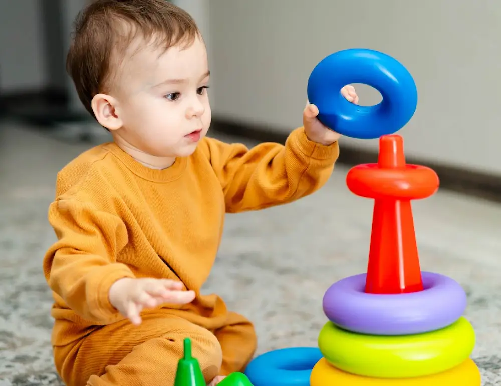 Bebé jugando con aros de colores en actividad de estimulación temprana en Pachuca