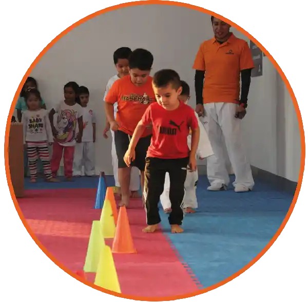 Niños participando en un circuito motriz con conos durante clases de Taekwondo en Lobos Pachuca